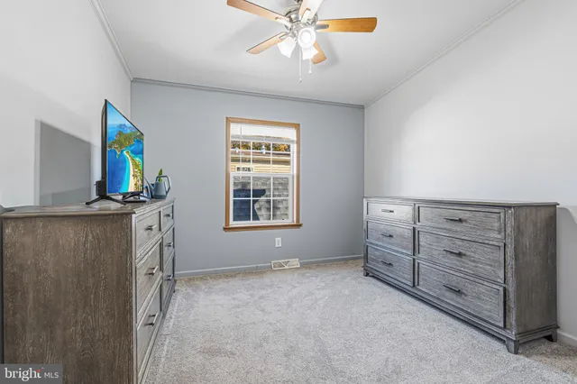 a view of an empty room with a window and dresser