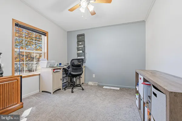 a view of a workspace with furniture and a window