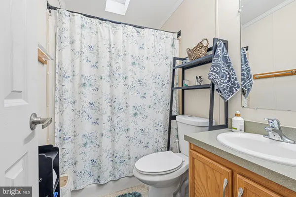a bathroom with a granite countertop toilet and a sink