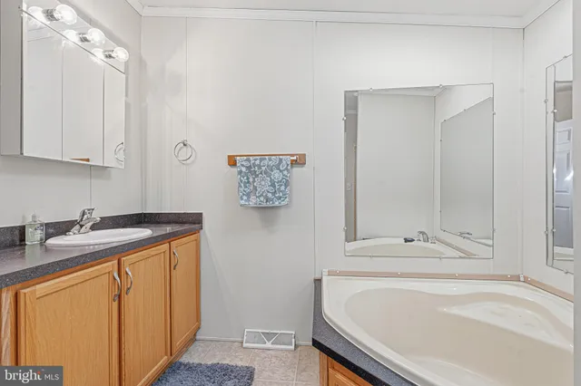 a bathroom with a granite countertop sink and a bathtub