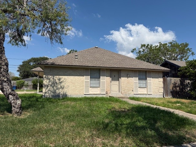 a view of a house with a yard and a large tree