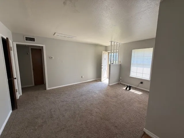 an empty room with windows and closet