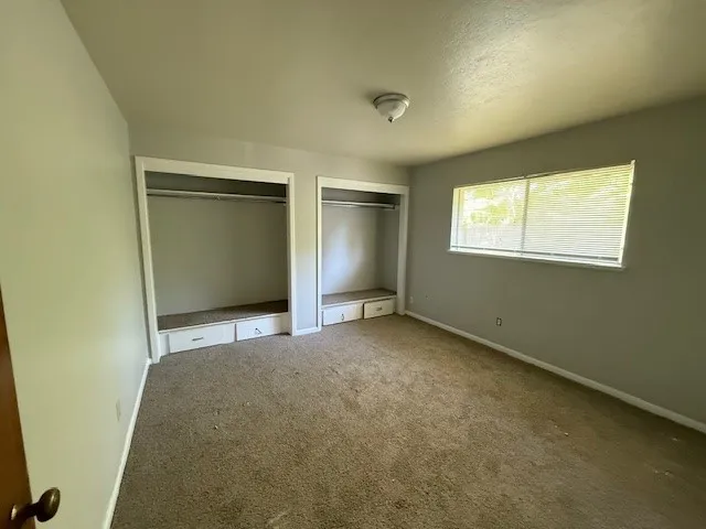 an empty room with windows and closet