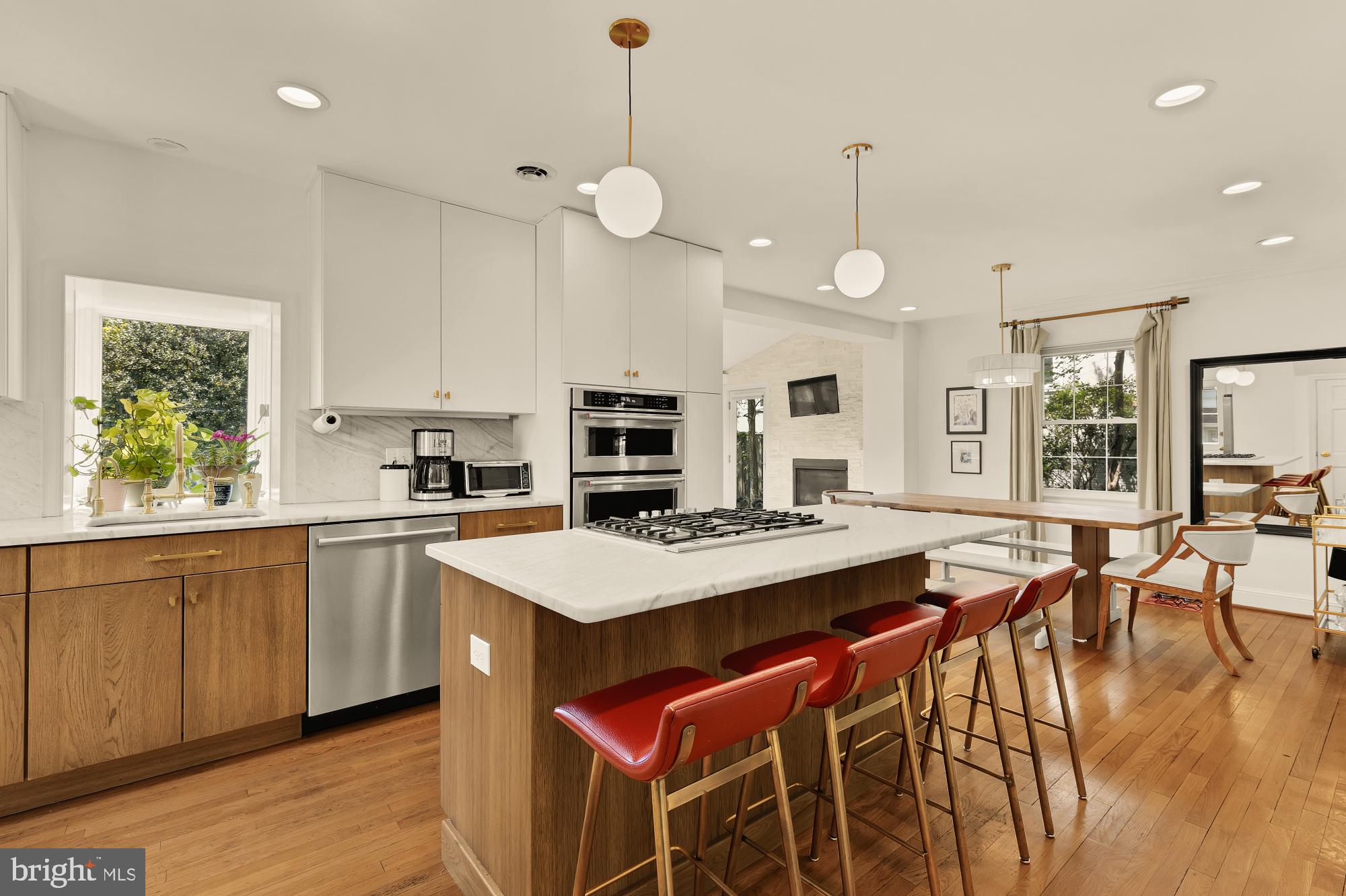7208 Delfield Street Chevy Chase, MD 20815 - Photo 15 of 50 a open kitchen with stainless steel appliances granite countertop a stove top oven a refrigerator a sink and a dining table with wooden floor