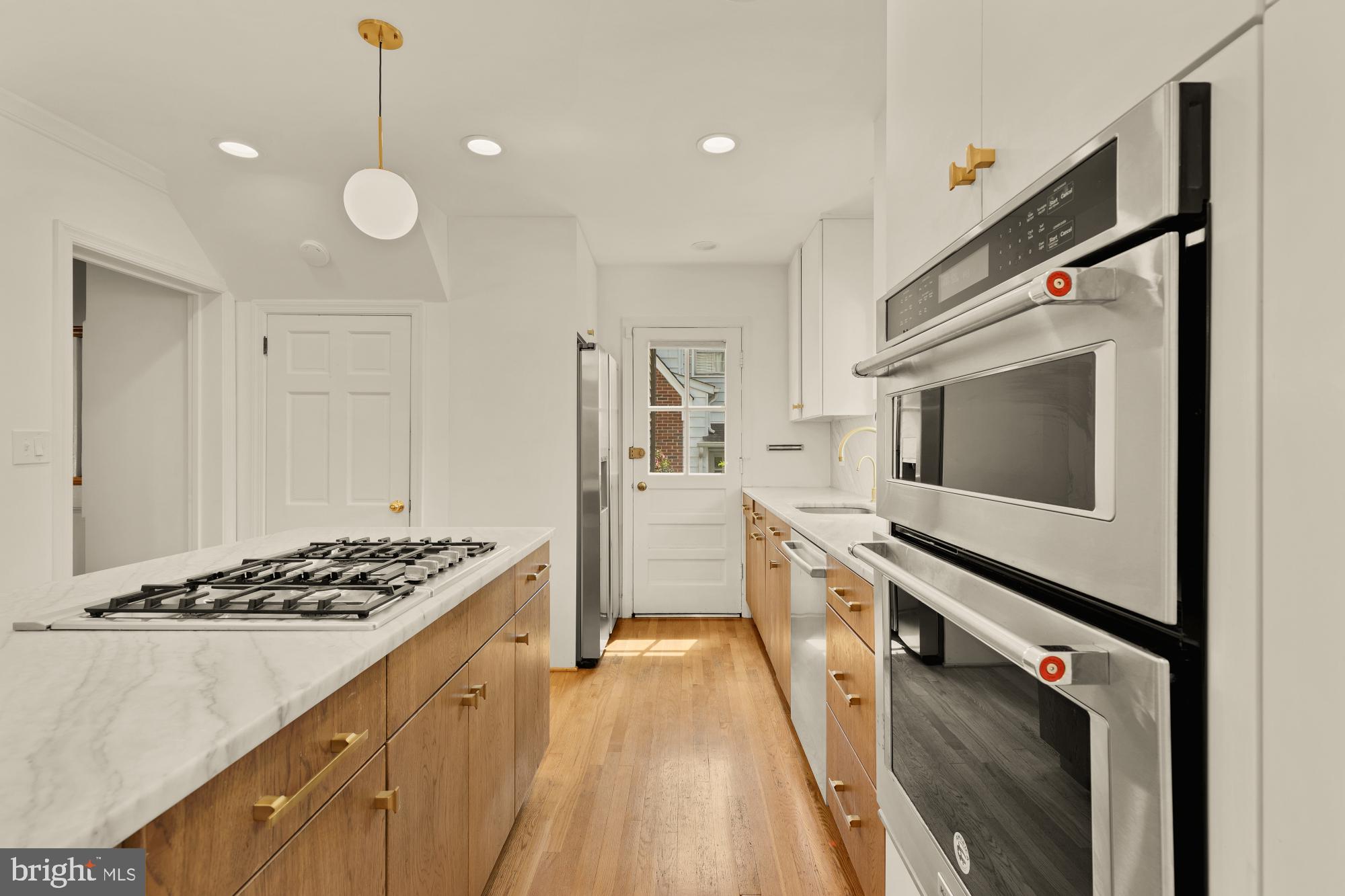 7208 Delfield Street Chevy Chase, MD 20815 - Photo 9 of 50 a kitchen with stainless steel appliances a stove a sink and a refrigerator