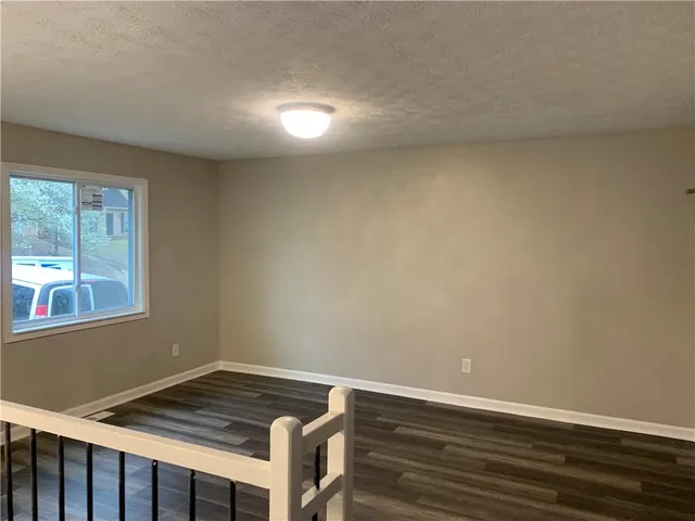 a view of room with window and wooden floor
