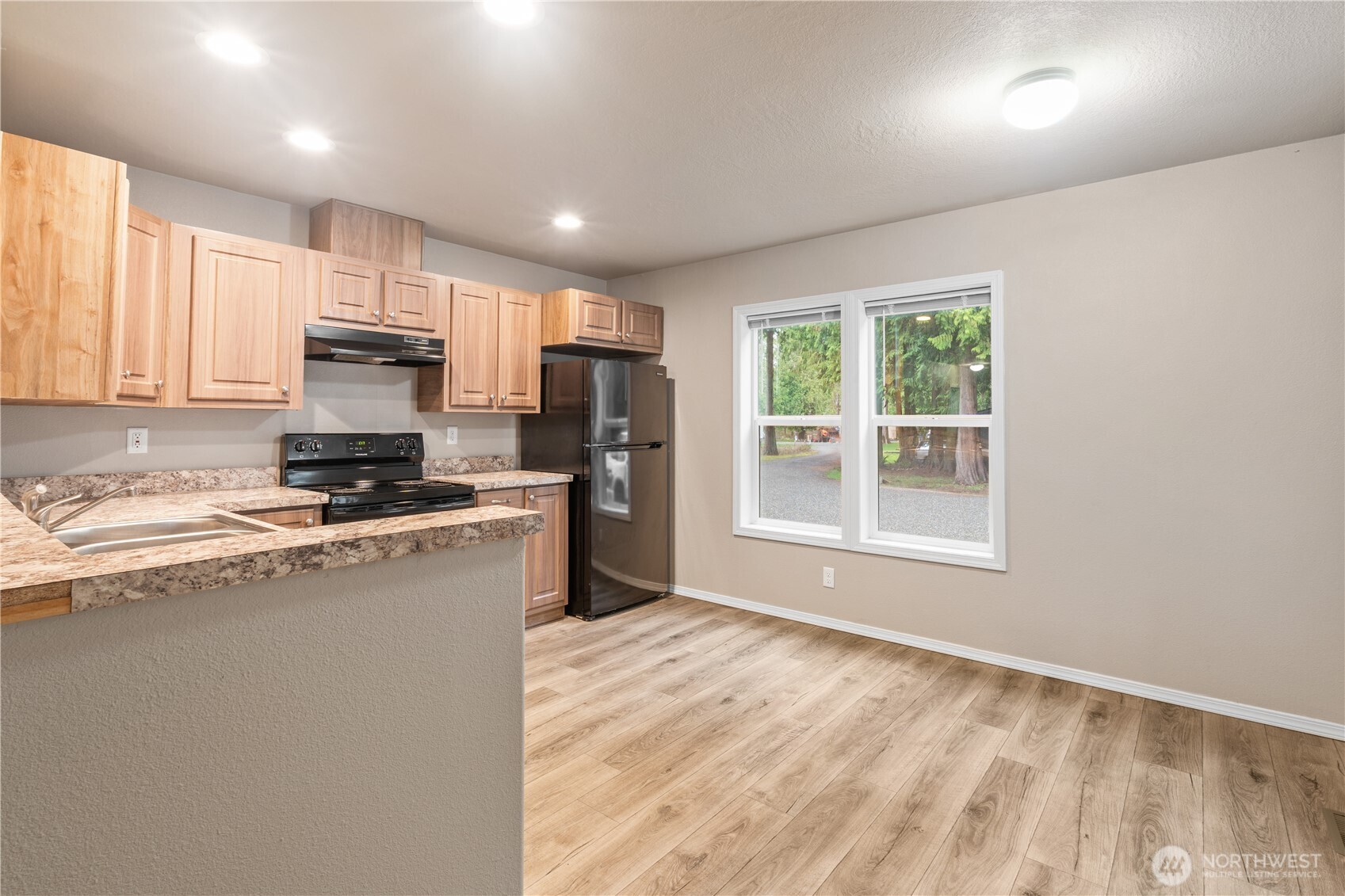 3557 Cedarville Road, Unit 25 Bellingham, WA 98226 - Photo 7 of 29 a kitchen with kitchen island a stove a sink a refrigerator a window and a counter top space
