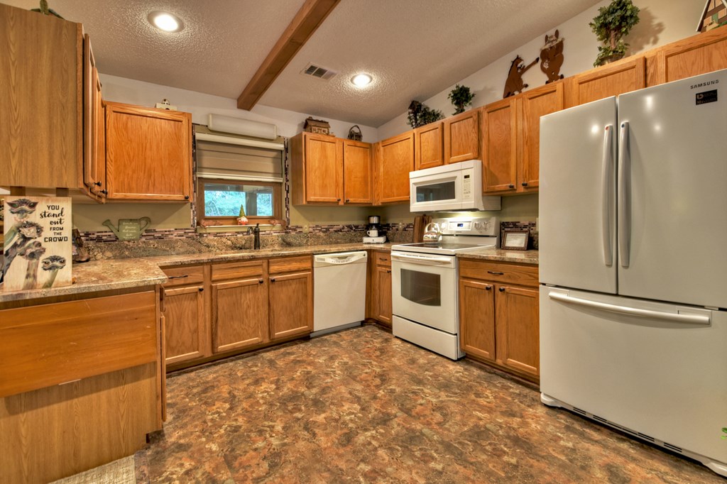 97 Mill Creek Acres Blue Ridge, GA 30513 - Photo 24 of 33 a kitchen with a sink refrigerator and cabinets