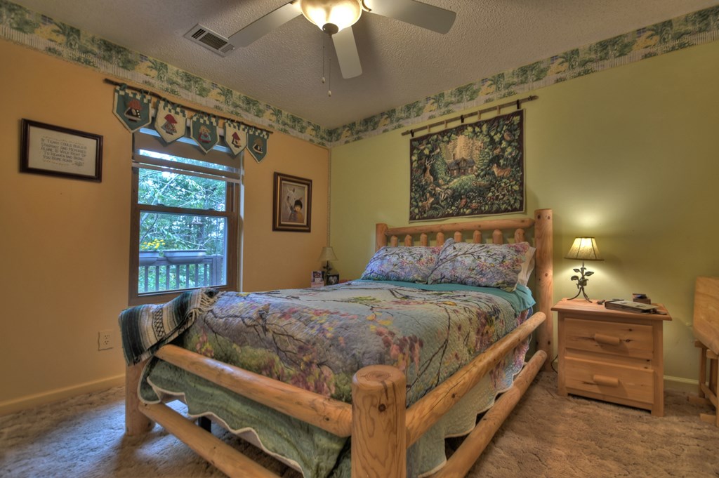 97 Mill Creek Acres Blue Ridge, GA 30513 - Photo 7 of 33 a bedroom with a bed and a chandelier