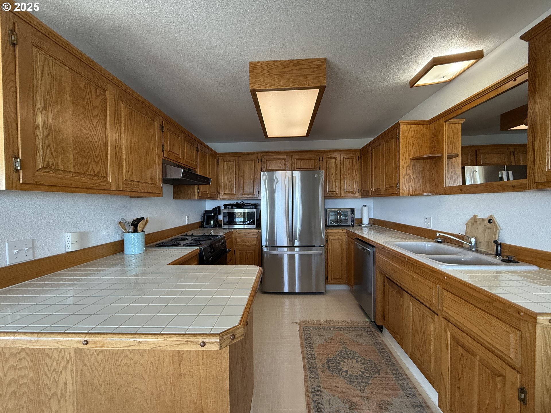 1305 Moore Street, Unit 402 Brookings, OR 97415 - Photo 13 of 28 a kitchen with stainless steel appliances granite countertop a sink a stove and a microwave