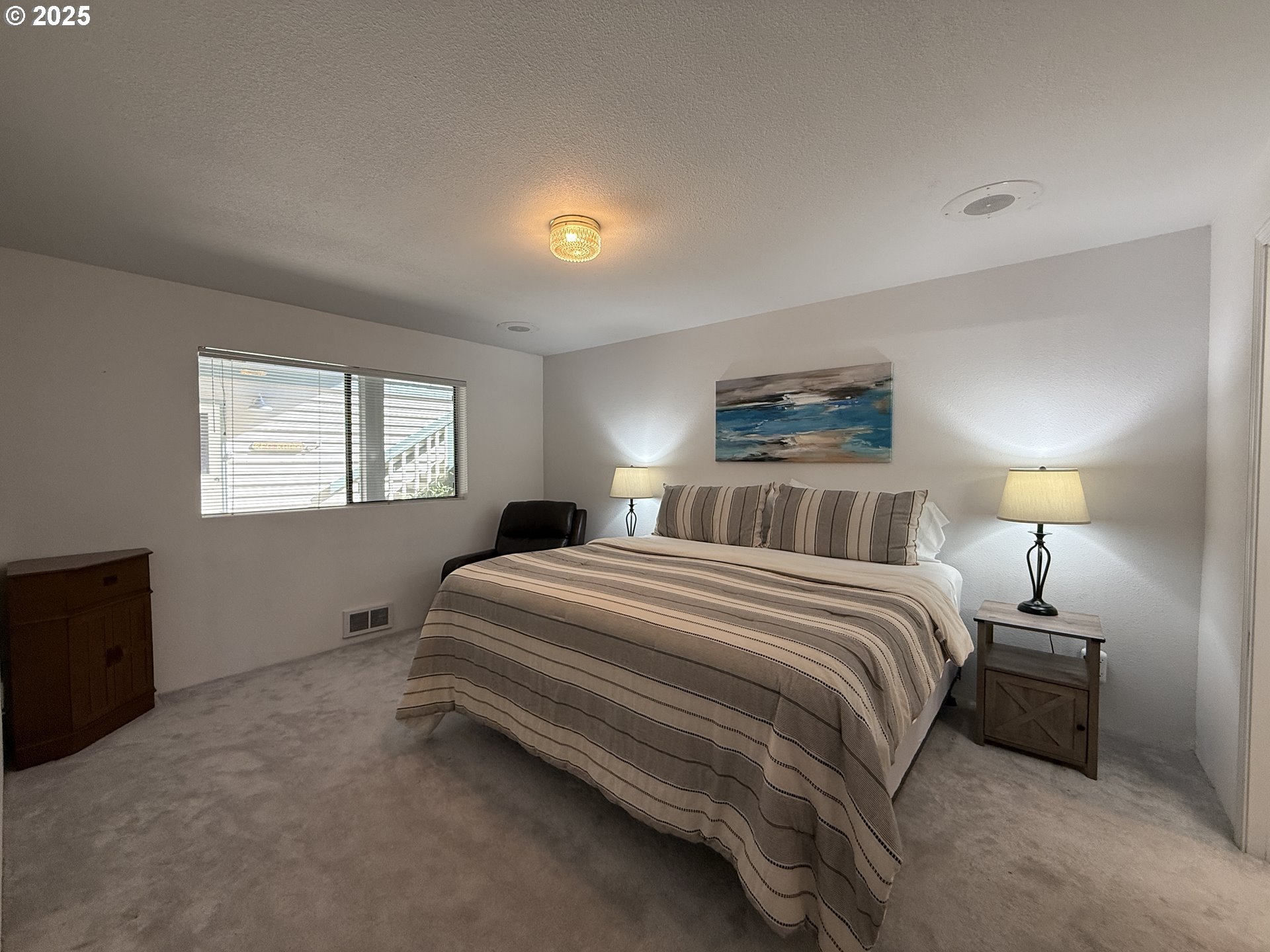 1305 Moore Street, Unit 402 Brookings, OR 97415 - Photo 17 of 28 a bedroom with a bed and a night stand