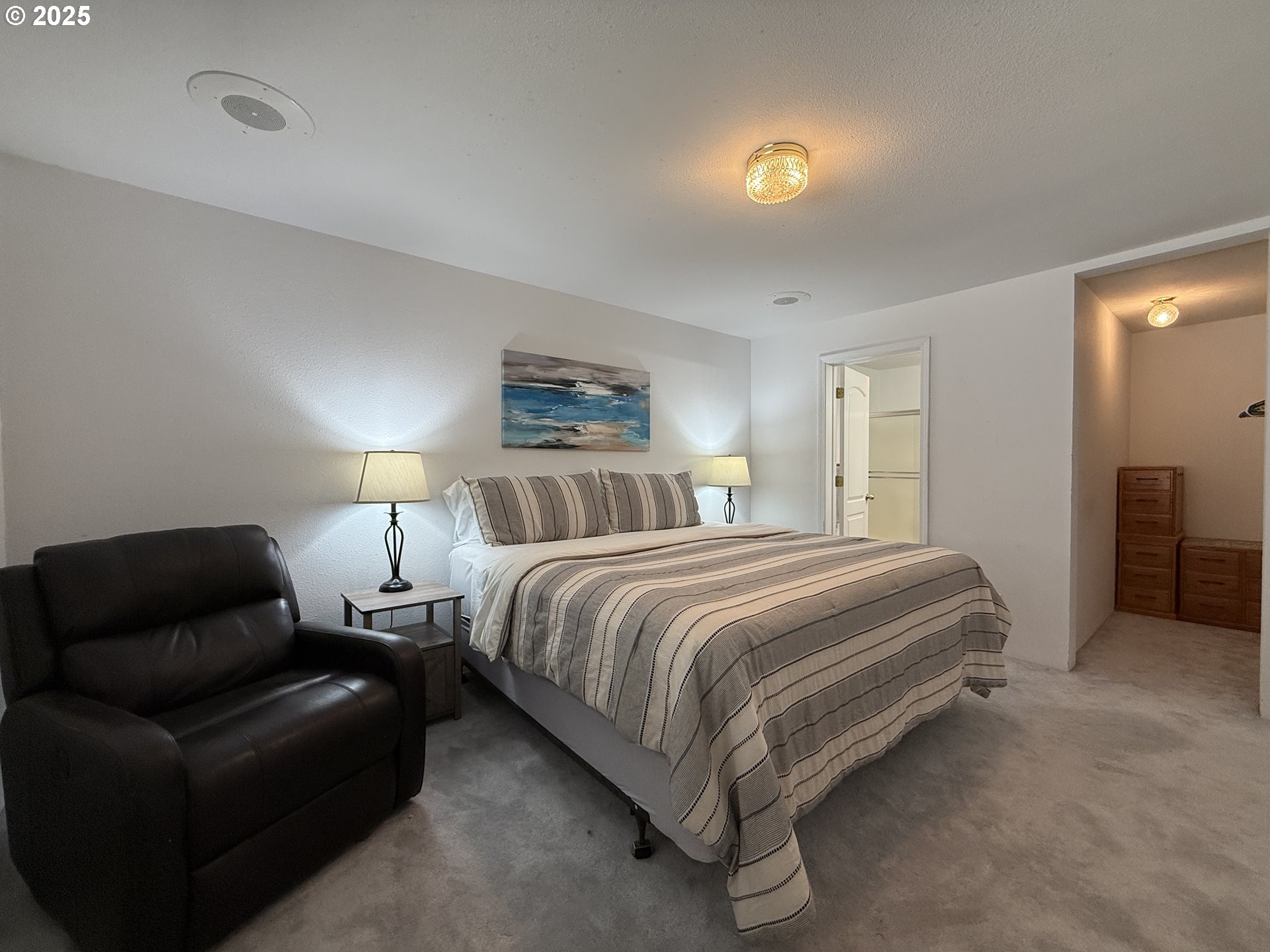 1305 Moore Street, Unit 402 Brookings, OR 97415 - Photo 19 of 28 a spacious bedroom with a bed and a lamp