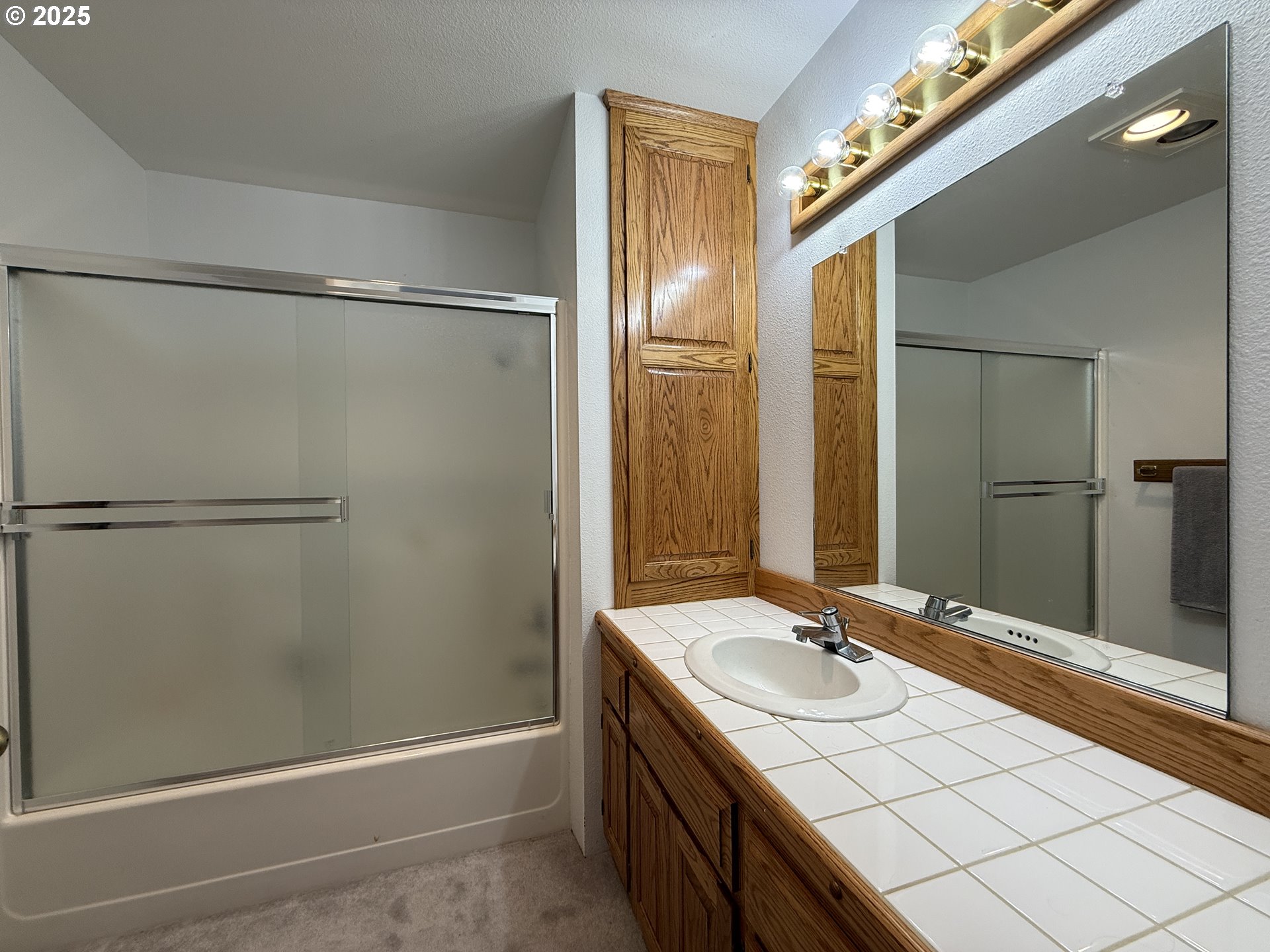 1305 Moore Street, Unit 402 Brookings, OR 97415 - Photo 20 of 28 a bathroom with a granite countertop sink mirror and shower