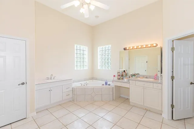 a bathroom with a bathtub a sink a mirror and a shower