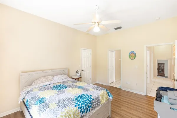 a spacious bedroom with a bed and a chandelier