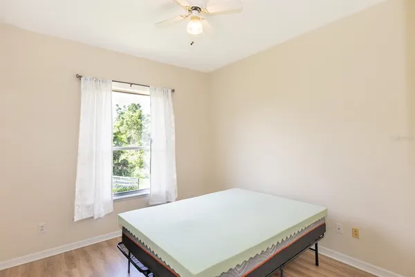 a bedroom with a bed and a chandelier fan