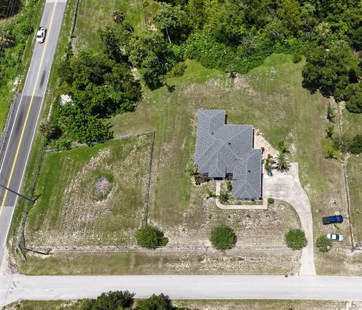 an aerial view of a house with a yard