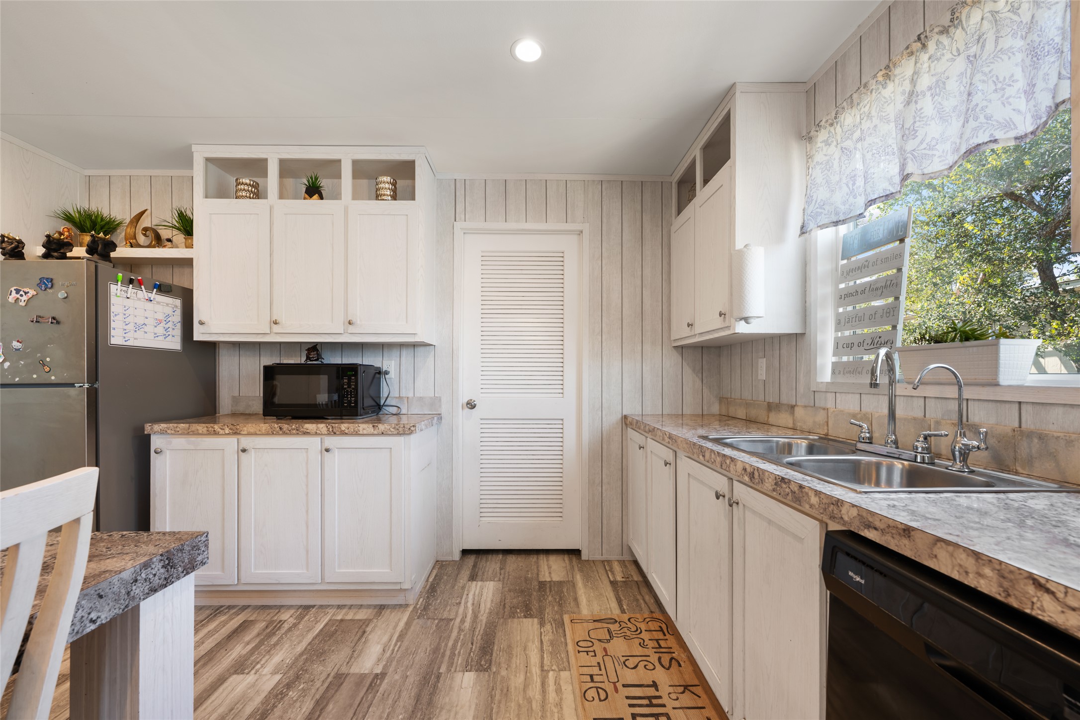 113 Sunflower Road Dale, TX 78616 - Photo 9 of 33 Laminate countertops and vertical paneling complement the cabinetry and wood-look flooring.