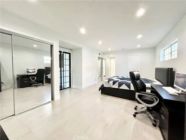 a bedroom with furniture and a large window