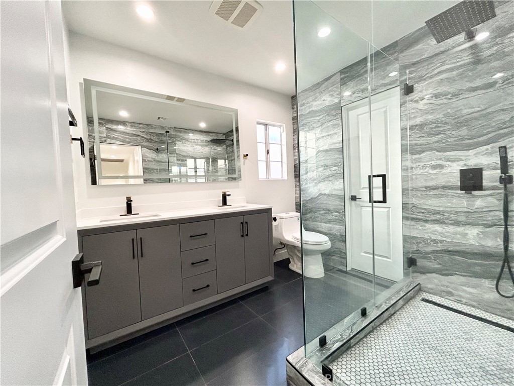 16754 Armstead Street Granada Hills, CA 91344 - Photo 17 of 28 a bathroom with a double vanity sink toilet and shower
