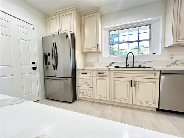 a kitchen with a refrigerator sink and cabinets