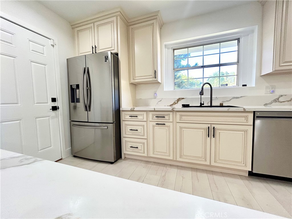 16754 Armstead Street Granada Hills, CA 91344 - Photo 2 of 28 a kitchen with a refrigerator sink and cabinets