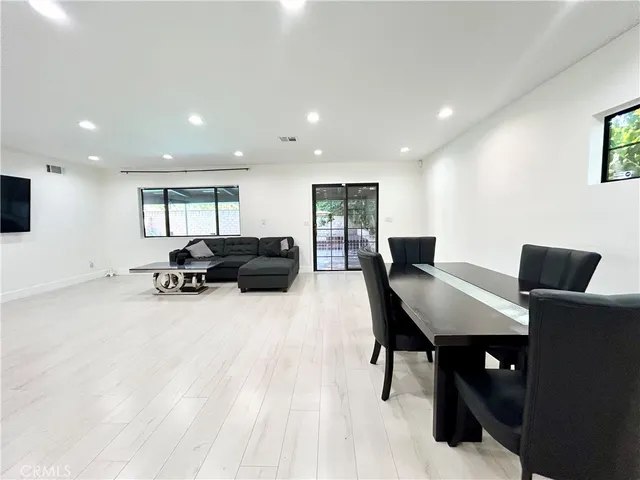 a living room with furniture a desk and a flat screen tv