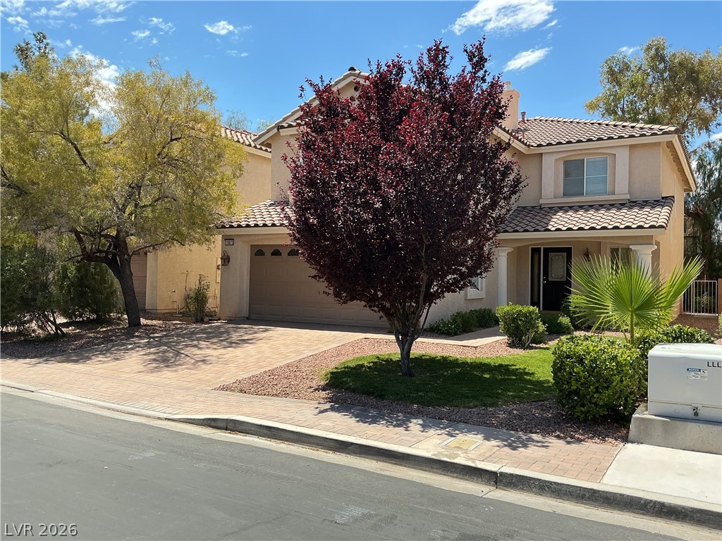 10975 Calcedonian Street Las Vegas, NV 89141 - Photo 2 of 25 This two-story residence presents a classic facade with a paver driveway and well-maintained landscaping.