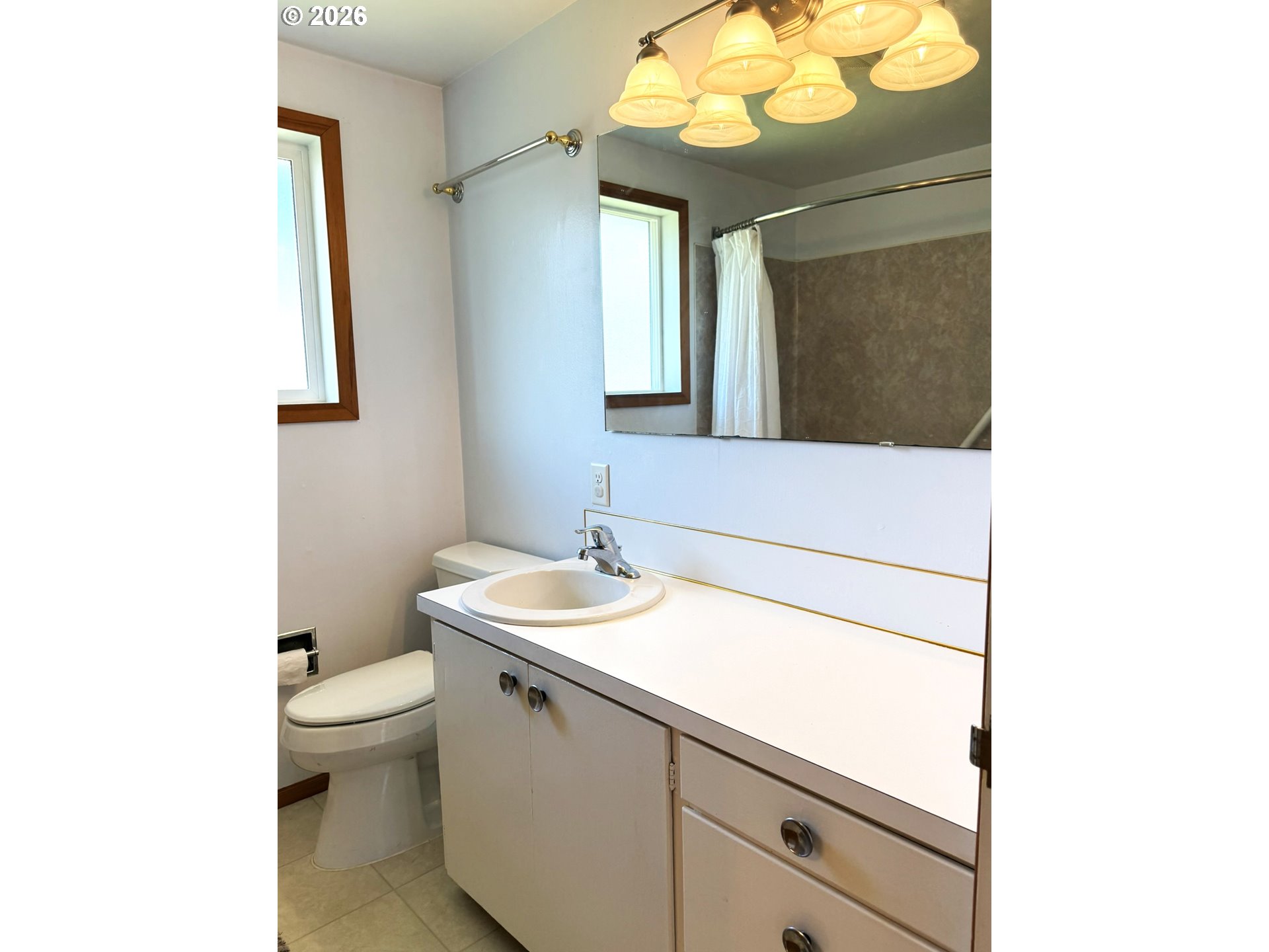 1179 6th Street Florence, OR 97439 - Photo 25 of 26 a bathroom with a toilet sink and mirror