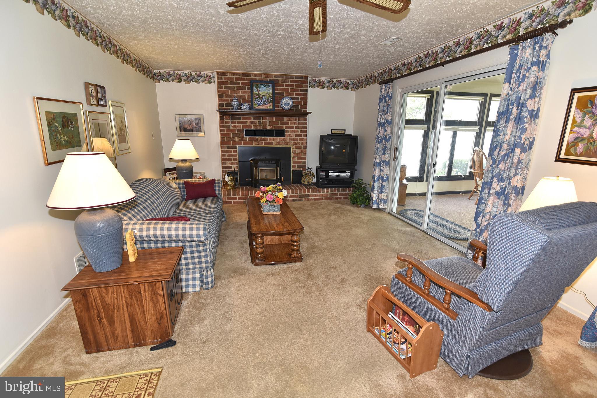 8219 Grainfield Road Severn, MD 21144 - Photo 12 of 30 a living room with furniture a fireplace and a table