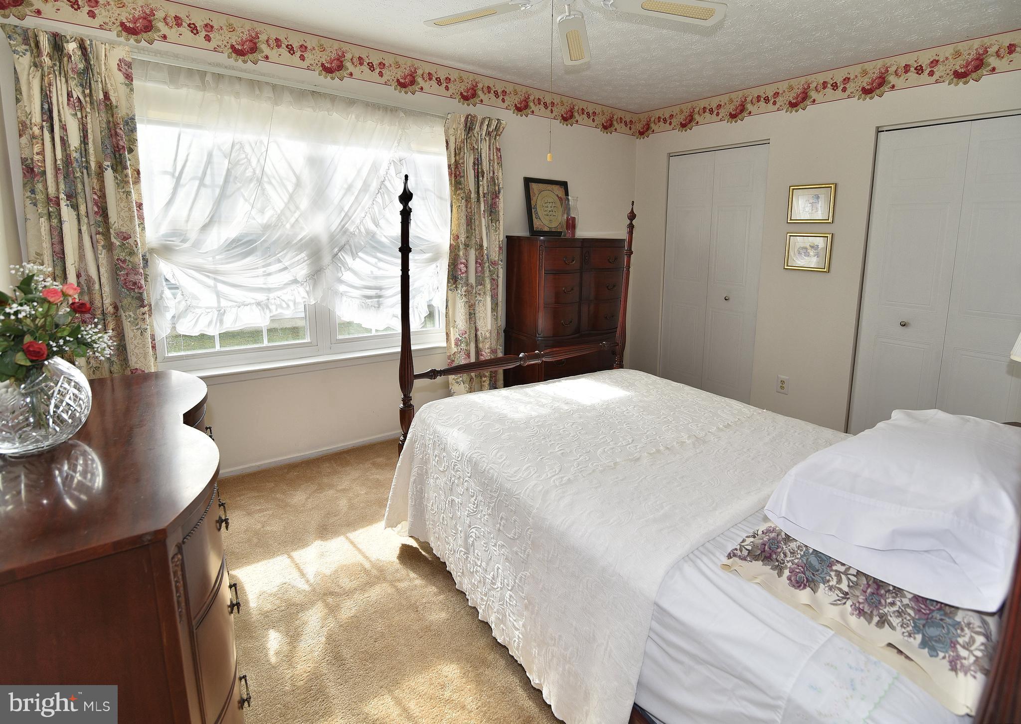 8219 Grainfield Road Severn, MD 21144 - Photo 15 of 30 a bedroom with a large bed and a potted plant
