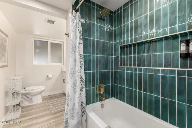 a bathroom with a toilet and a shower