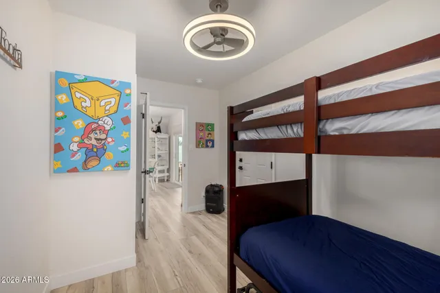a view of a hallway to room with wooden floor and furniture