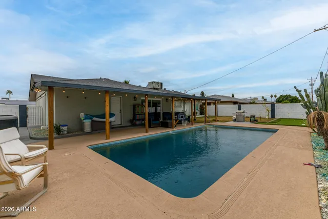 a view of a house with swimming pool and sitting area