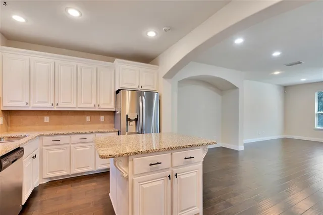 a kitchen with white cabinets and sink
