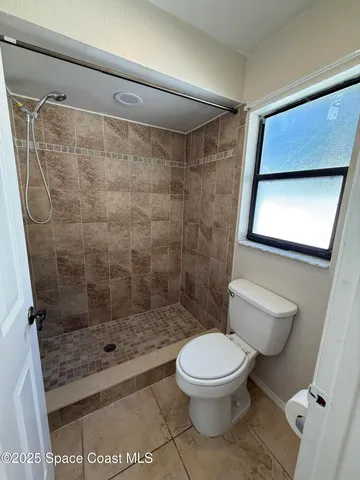 a white toilet sitting next to a bathroom sink