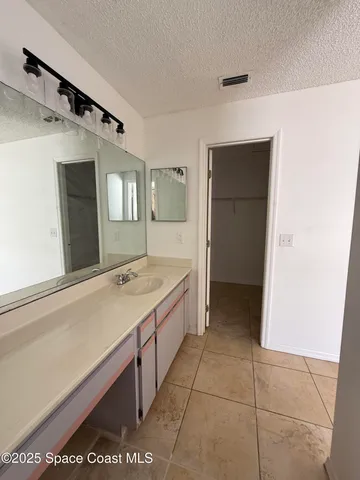 a spacious bathroom with a granite countertop sink and a mirror