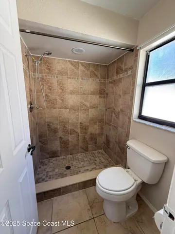 a bathroom with a toilet and a shower