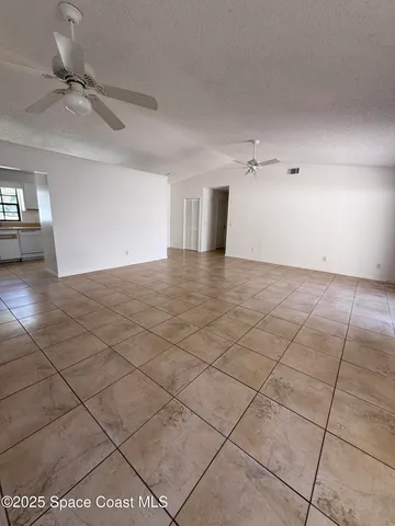 a view of a livingroom with a ceiling fan and window