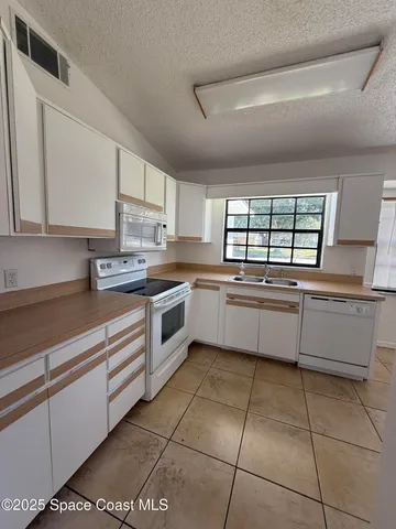a kitchen with a cabinets stainless steel appliances and a window