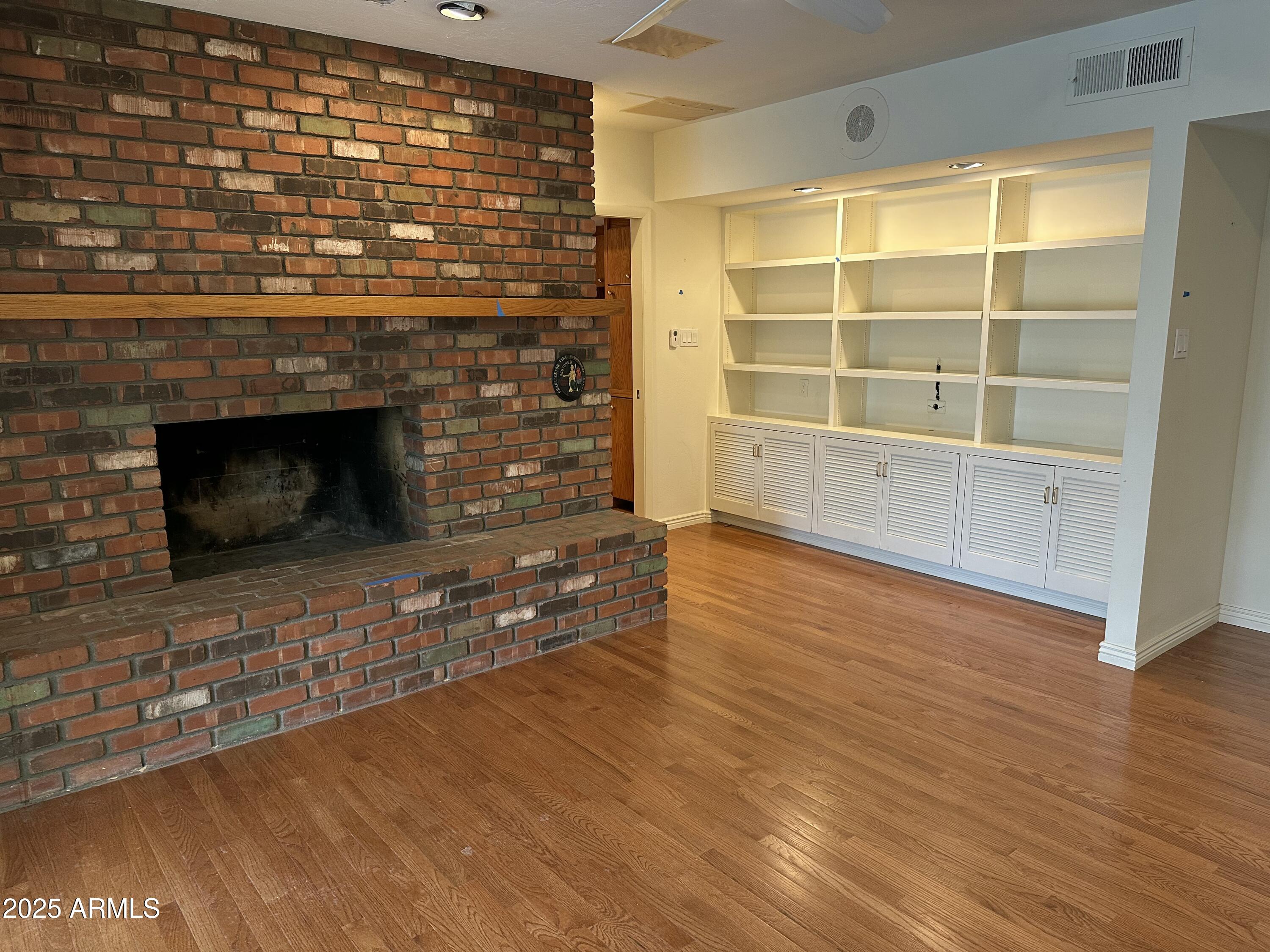 511 West Ocotillo Road Phoenix, AZ 85013 - Photo 7 of 14 a view of an empty room with wooden floor and a fireplace