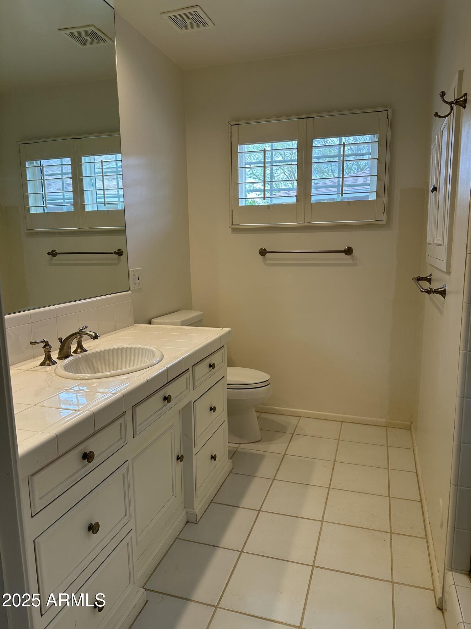 511 West Ocotillo Road Phoenix, AZ 85013 - Photo 10 of 14 a bathroom with a sink a toilet and a window