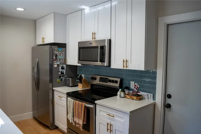 a kitchen with a table chairs and white cabinets