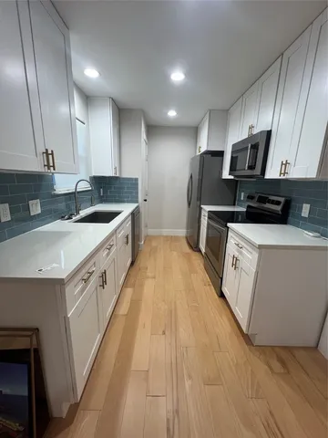 a large kitchen with stainless steel appliances granite countertop a sink and a stove