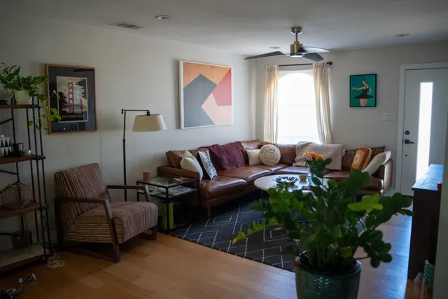 a living room with furniture and a potted plant