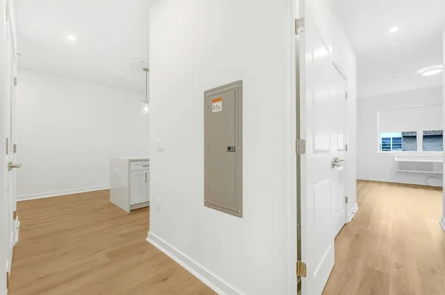 a view of a room with wooden floor and a bathroom