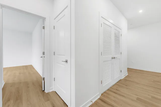 a view of a hallway with wooden floor