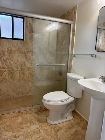 a bathroom with a toilet and a shower