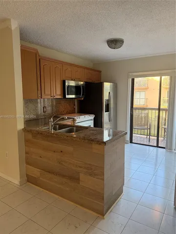a kitchen with kitchen island a sink stainless steel appliances and window