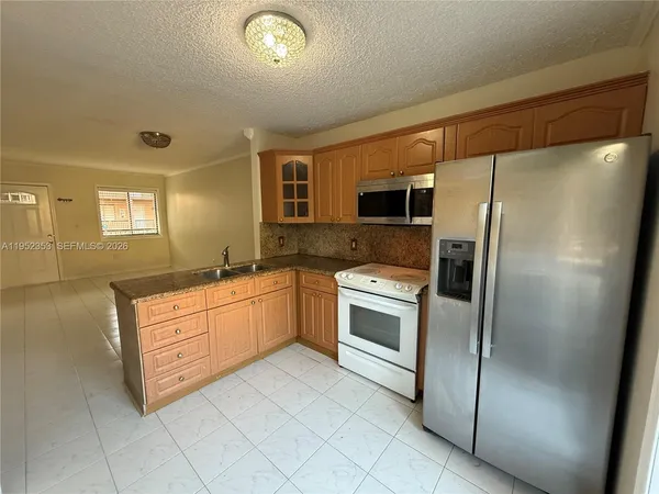 a large kitchen with a refrigerator sink and cabinets